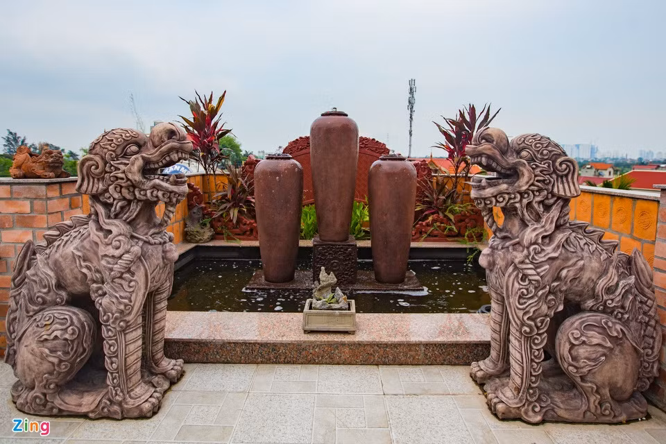 Tại khuôn viên tầng thượng, gia đình chị Liên trang trí thêm tiểu cảnh, hồ cá... với lối bài trí thuần Việt. Ngoài ra, nhiều sản phẩm do gia đình anh chị Liên làm ra như tượng phật, cặp nghê... cũng được trưng bày quanh sân.