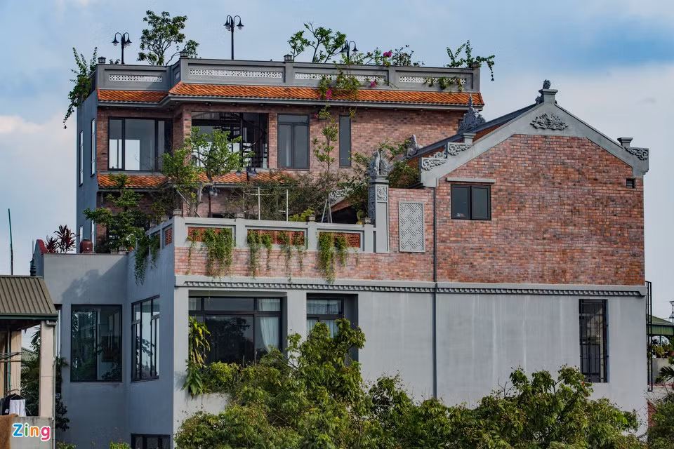 Nhìn từ xa trên đường đê Liên Mạc, ngôi nhà nổi bật hẳn lên. Phía bên ngoài ốp nền gạch tường chịu lửa giả cổ.