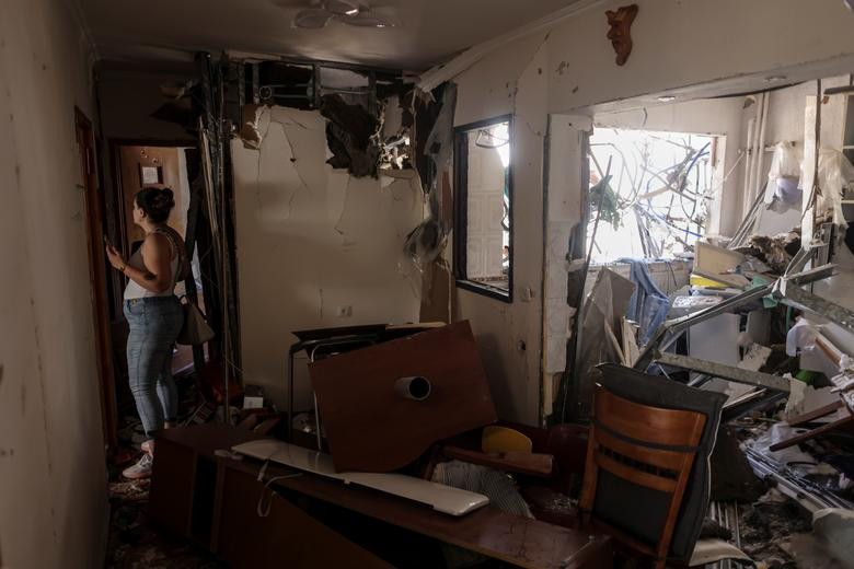 Người phụ nữ đứng trong căn hộ bị hư hại của cha mẹ cô ở Ashdod, Israel, ngày 17/5.