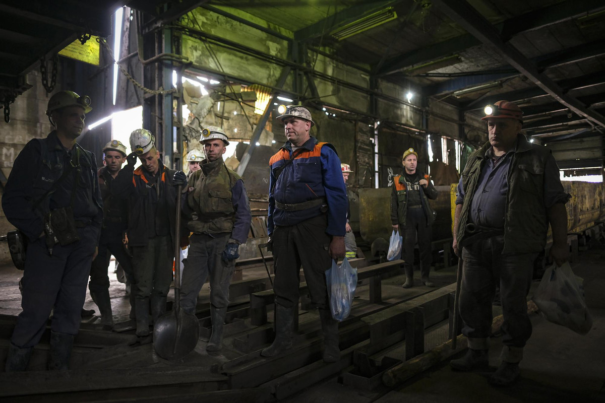 Nhóm thợ mỏ chờ thang đưa họ xuống lòng đất.