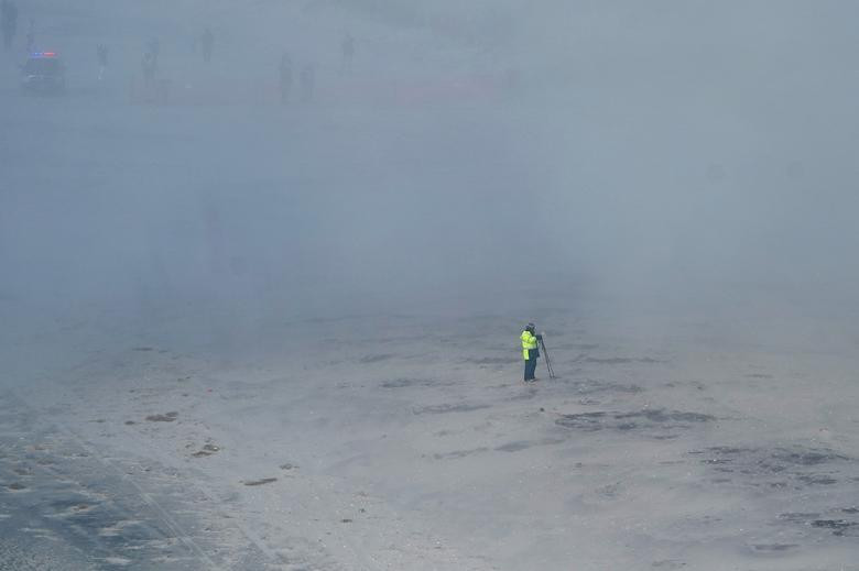 Khói bụi bao trùm một nhiếp ảnh gia gần nơi tòa Trump Plaza bị đánh sập hôm 17/2. 