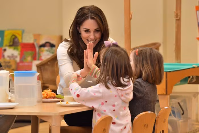 Công nương Kate Middleton và Hoàng tử William khi đó vẫn thực hiện các nhiệm vụ với tư cách là thành viên trong gia đình Hoàng gia Anh mà không cần đeo khẩu trang. Ảnh: Công nương Kate thăm một trường mẫu giáo ở London ngày 29/1/2020. Cô trò chuyện vui vẻ với các em nhỏ.