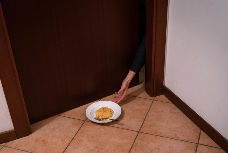 Cô Chiara lấy đĩa thức ăn mang vào phòng ăn trong thời gian tự cách ly.