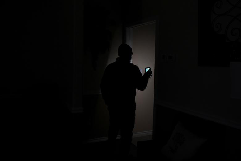 Chuck Pryor, giám đốc nhà tang lễ Pryority Funeral Experience, soi điện thoại đi kiểm tra ở Houston, Texas, ngày 16/2.