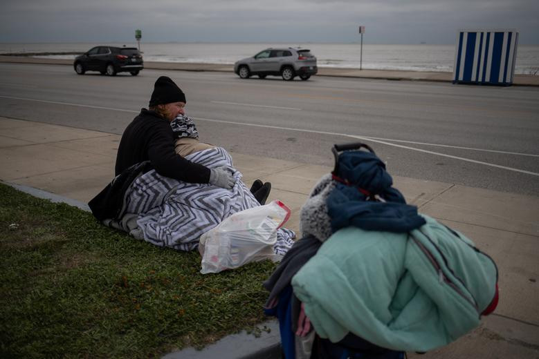 Loạt ảnh của hãng Reuters phần nào cho thấy tình cảnh khó khăn của người dân Texas những ngày này. Ảnh: Renne Alva, 37 tuổi, và Travis Wasicek, 43 tuổi, ôm nhau để giữ ấm khi ngồi ngoài trời ở khu vực đại lộ Seawall ở Galveston, Texas, ngày 18/2. Họ trở thành người vô gia cư sau khi mất việc làm do ảnh hưởng của đại dịch COVID-19.