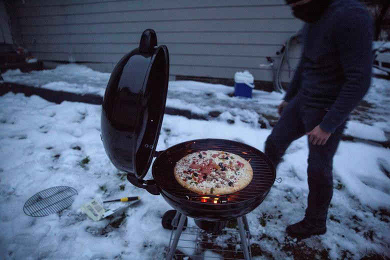 Max King sử dụng bếp than mà anh mua để làm bánh pizza khi mất điện ở San Marcos.