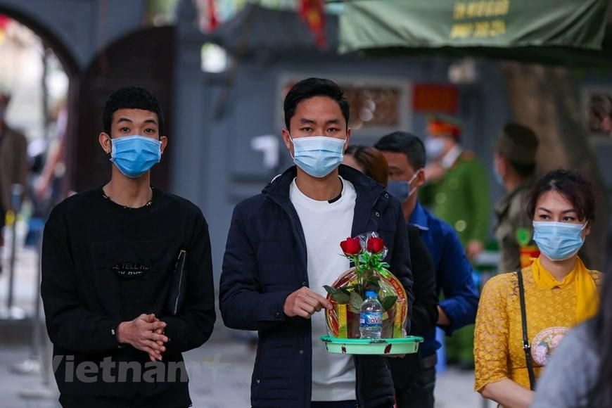 Các bạn trẻ đến chùa Hà thắp hương, xin sớ, dâng lễ để cầu may mắn, bình an và đặc biệt tìm được 'một nửa' của đời mình. (Ảnh: Minh Sơn/Vietnam+)