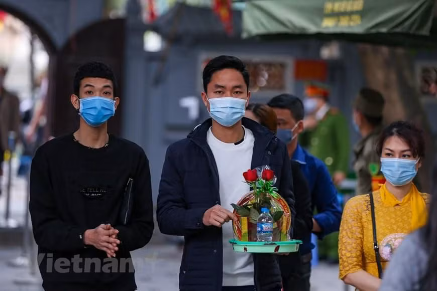 Các bạn trẻ đến chùa Hà thắp hương, xin sớ, dâng lễ để cầu may mắn, bình an và đặc biệt tìm được 'một nửa' của đời mình. (Ảnh: Minh Sơn/Vietnam+)