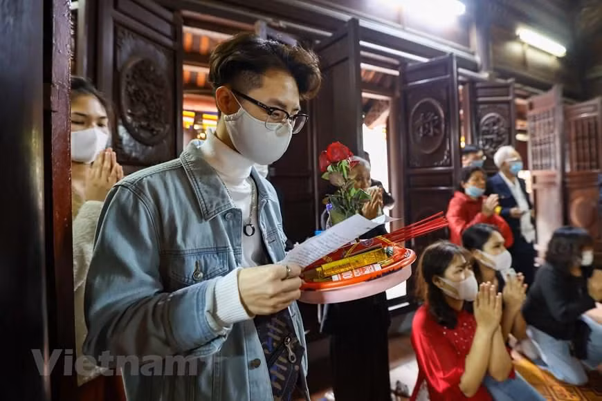 Bạn Nguyễn Minh Hiệp (Gia Lâm, Hà Nội) chia sẻ: 'Em được biết chùa Hà là nơi cầu duyên rất linh nên hôm nay em đến đây vừa là để cầu bình an, sức khỏe và vừa cầu duyên. Hi vọng năm mới em sẽ có người yêu.' (Ảnh: Minh Sơn/Vietnam+)