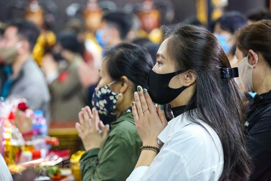 Việc thực hiện giãn cách tối thiểu giữa người với người rất khó thực hiện khi số lượng người dân đến chùa rất đông. (Ảnh: Minh Sơn/Vietnam+)