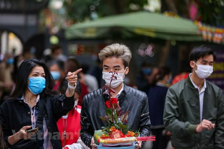 Nhiều bạn trẻ đến chùa Hà lần đầu để cầu duyên nên còn bỡ ngỡ, cần người hướng dẫn cúng bái theo đúng trình tự. (Ảnh: Minh Sơn/Vietnam+)