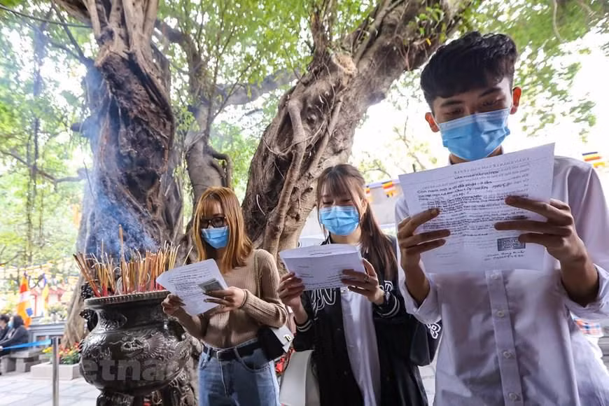 Mọi người đến chùa Hà với ước mong năm mới được bình an, hạnh phúc, cầu cho tình duyên bền chặt với các bạn đang yêu hoặc đã có bạn đời, còn ai chưa có người yêu thì cầu mong sớm có được mối duyên lành. (Ảnh: Minh Sơn/Vietnam+)