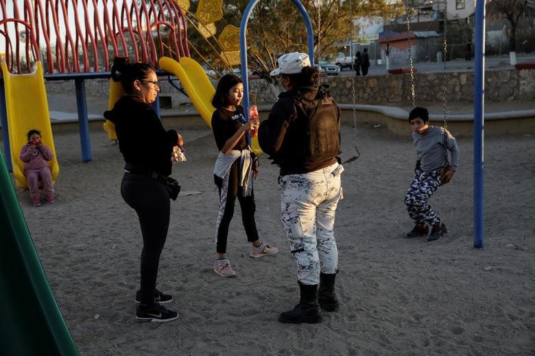 Thành viên của lực lượng Vệ binh Quốc gia Mexico yêu cầu di dân rời khỏi một công viên ở Ciudad Juarez.