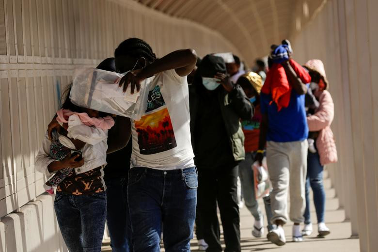 Một số di dân đến từ Haiti đi bộ qua cây cầu Zaragoza-Ysleta sau khi bị trục xuất khỏi Mỹ.