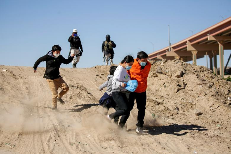 Hình ảnh người dân di cư đến từ Trung Mỹ tháo chạy ở Ciudad Juarez để tìm cách vượt sông Rio Bravo. 