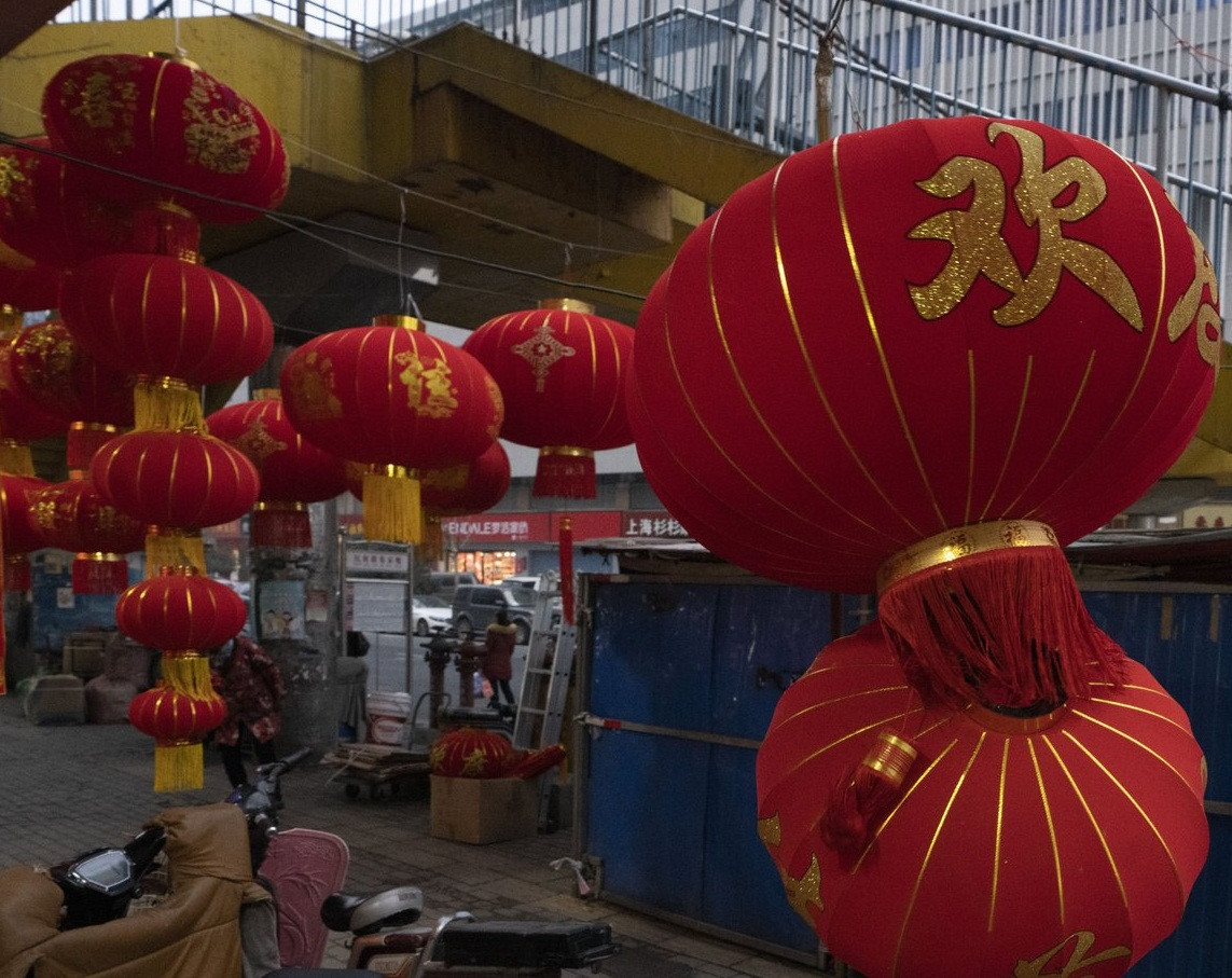 Theo AP, khi Tết Nguyên đán 2021 đang cận kề, những chiếc đèn lồng đỏ rực rỡ được treo khắp một con hẻm ở Vũ Hán, nơi từng là "tâm dịch" COVID-19 ở tỉnh Hồ Bắc (Trung Quốc), nhưng chỉ có lác đác một vài khách hàng hỏi mua. (Nguồn ảnh: AP)