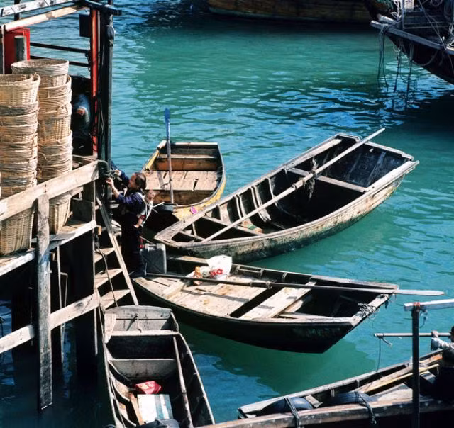 Cụ bà và em bé trên con thuyền ở cảng Aberdeen, 1973. Ảnh: Keith Macgregor.