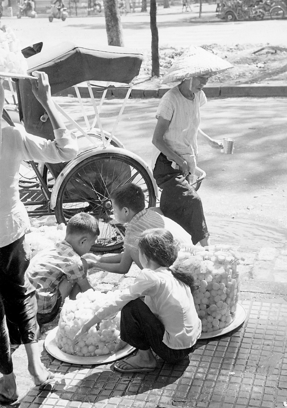 Chiếc xe xích lộ đỗ bên quầy bán mía ghim ở khu vực trung tâm Sài Gòn. Ảnh: Vietnam Center and Archive.