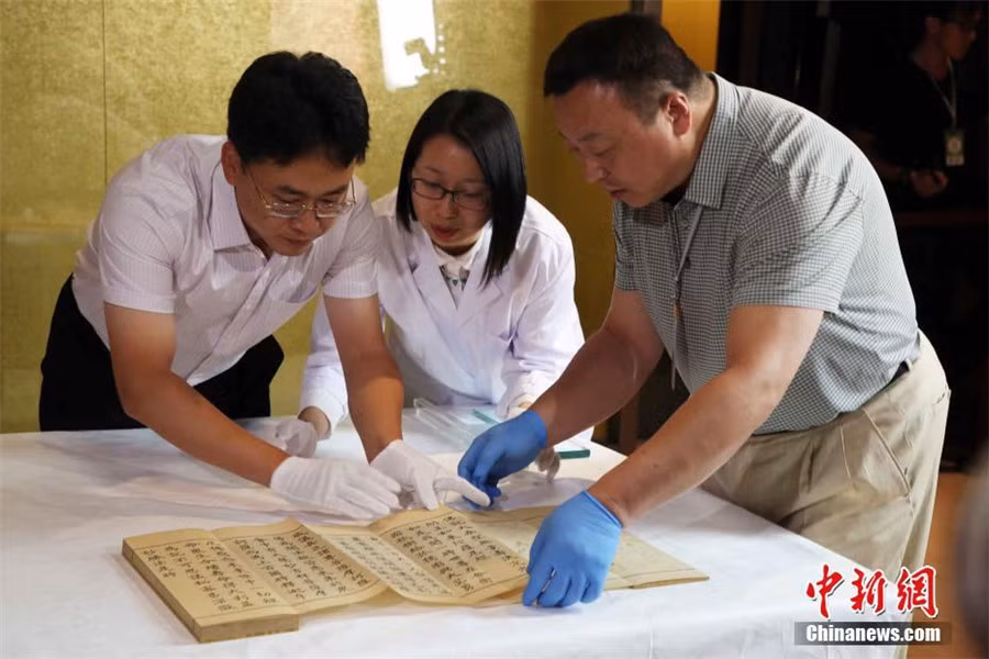 Nhân viên bảo tàng cẩn thận lật mở từng trang sách cổ. Đây là một trong số nhiều cổ vật quý giá có từ thời nhà Thanh.