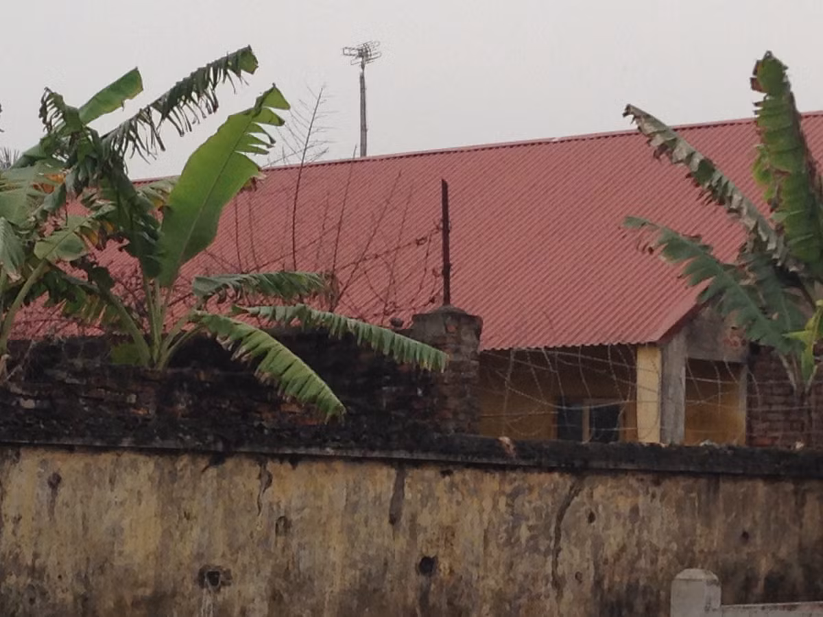 Mặt sau trại giam, dây thép gai cũng dày đặc.