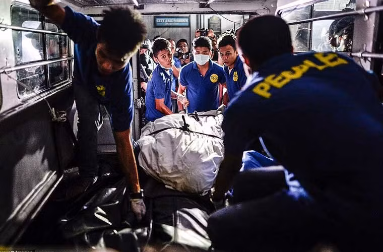 Các nhân viên nhà tang lễ đưa thi thể một tội phạm bị tiêu diệt ở nhà tù thành phố Paranaque, nơi xảy ra một vụ nổ lựu đạn khiến 10 tù nhân chết. Trong đó, 8 nghi phạm đang chờ xét xử do liên quan tới ma túy.