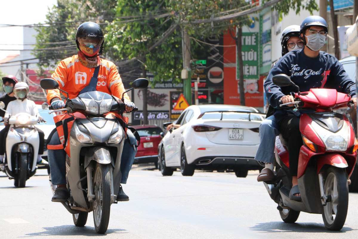 Anh Thành tiếp tục đội nắng đồ ăn giao cho khách. 