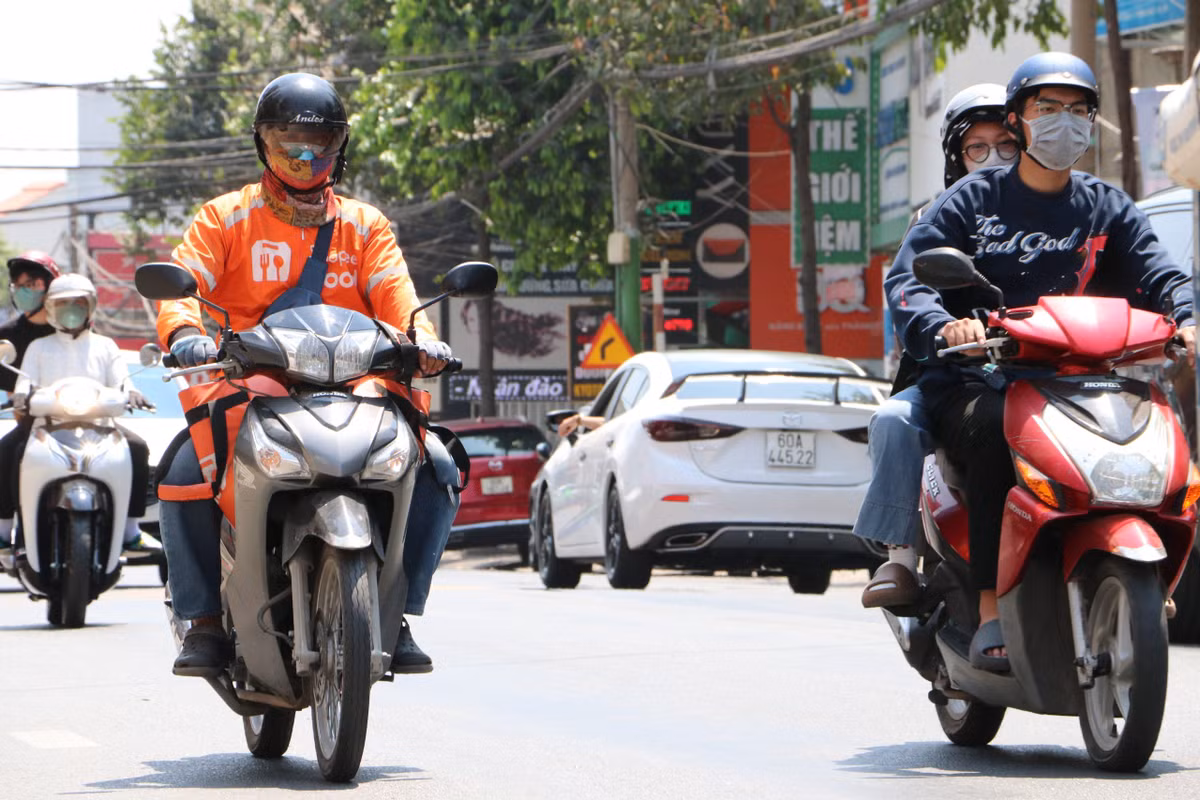 Anh Thành tiếp tục đội nắng đồ ăn giao cho khách. 