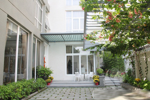 Nhấn mạnh yếu tố cây xanh, cỏ cây để tạo cảnh quan thiên nhiên cho biệt thự, các kiến trúc sư đã tư vấn thiết kế khoảng sân vườn nhỏ, với giàn hoa, chậu cảnh tươi tốt. Ảnh: Eva.