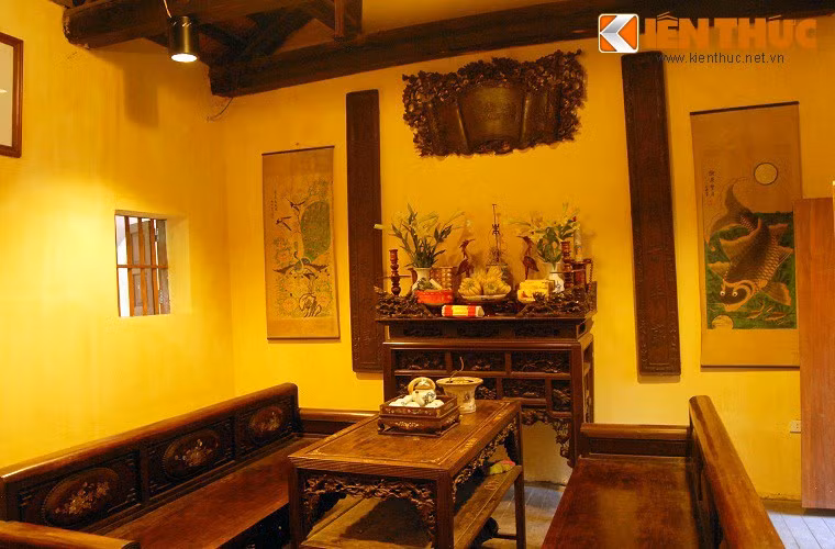 Căn phòng nhỏ và ấm cúng, có hoành phi câu đối, bộ trường kỷ tiếp khách và trên tường treo bộ tứ quý khắc gỗ.