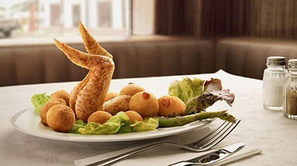 Đĩa ăn gồm cánh gà, bánh chiên phồng, xà lách, măng tây được bày biện giống hệt một mỹ nữ khỏa thân nóng bỏng trên bàn tiệc.