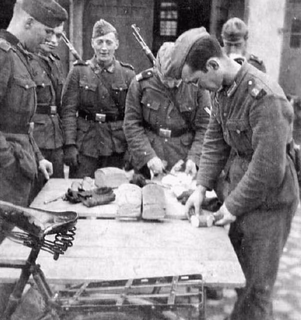 Các sỹ quan đang chia khẩu phần ăn cho binh lính. Bánh mỳ là khẩu phần ăn rất gọn nhẹ và dã chiến, không cần phải hâm nóng, không cần phải lích kích bát đũa như lúc ăn cơm, người lính chỉ việc cầm chiếc bánh mỳ lên và gặm, thậm chí có thể vừa ăn vừa hành quân. Nguồn ảnh: Histomil.