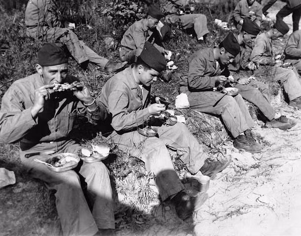 Dù cuộc chiến có ác liệt đến mấy, người lĩnh cũng vẫn cứ phải ăn đủ bữa, ngủ đủ giấc để có sức chiến đấu. Binh lính trong Chiến tranh thế giới thứ hai cũng vậy, họ tranh thủ những khoảng thời gian ít ỏi trong ngày để "ăn vội ăn vàng". Ảnh: Binh lính Mỹ ngồi ăn trưa trong chiến hào. Nguồn ảnh: Pinterest.