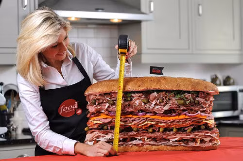 Bánh sandwich với 41 miếng thịt kẹp giữa được bày bán trong một triển lãm ẩm thực ở Anh ngày 22/5/2012 đã trở thành chiếc bánh sandwich kẹp nhiều thịt nhất thế giới. Chiếc bánh này cao 38cm, có 1.445gr thịt giăm bông, 2kg xúc xích ý và thịt gà tây, 720gr thịt nguội và 1kg thịt xay. (Nguồn: CCTVNews)