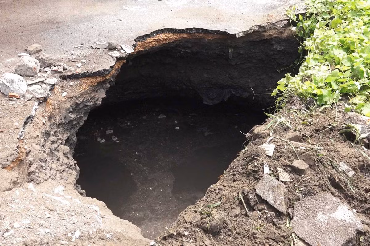 Ngày 24/6, tại khu dân cư TP Cẩm Phả, Quảng Ninh, đã xuất hiện hai "hố tử thần" sau trận mưa ngày 22/6. Một hố sụt sâu hơn 3,5m xuất hiện trên mặt đường tại tổ 1, khu Nam Sơn 2, phường Cẩm Sơn. Lực lượng chức năng đã khẩn trương khảo sát và cảnh báo người dân, đồng thời triển khai phương tiện lấp hố. (Ảnh: Cổng thông tin TP Cẩm Phả)