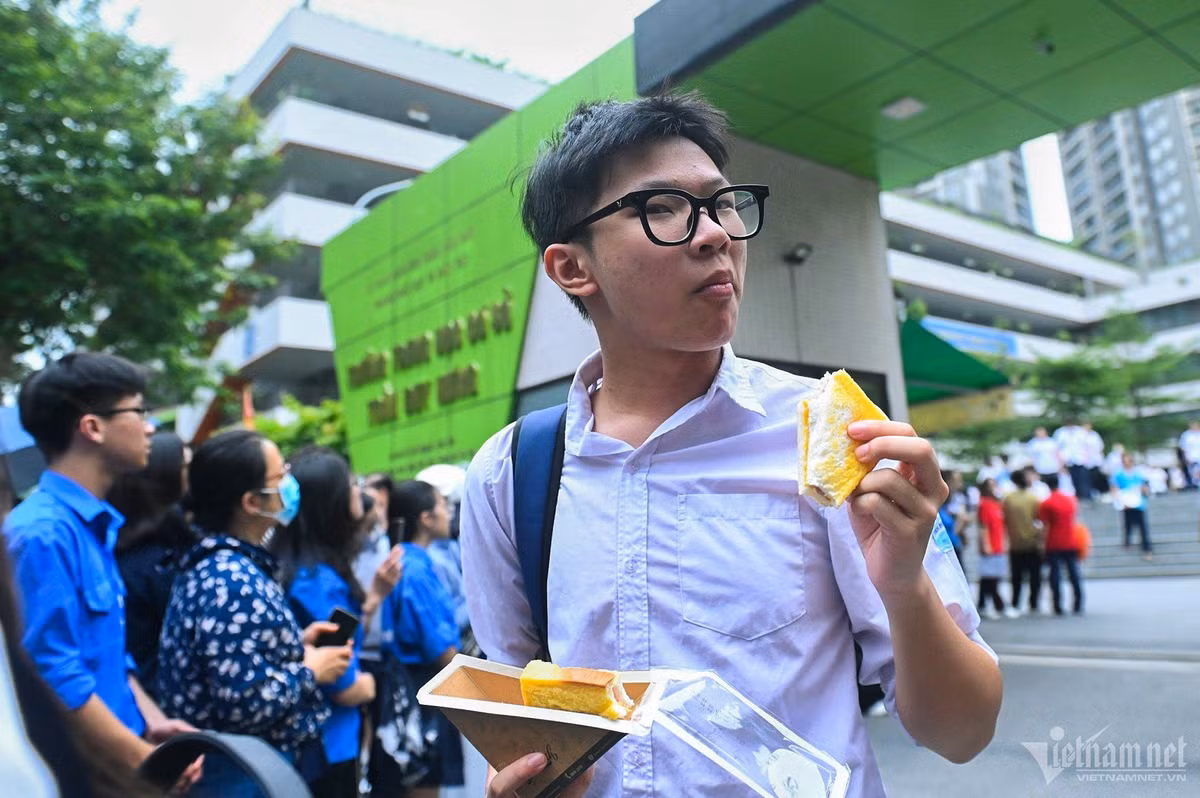 Đề thi Tiếng Anh buổi chiều có phần "dễ thở" hơn, phần lớn thí sinh đều vui vẻ, tự tin khi bước ra khỏi cổng trường. Một nam sinh khá hài lòng với những thể hiện của mình. Em nhanh chóng lót dạ chiếc bánh sau giờ thi căng thẳng