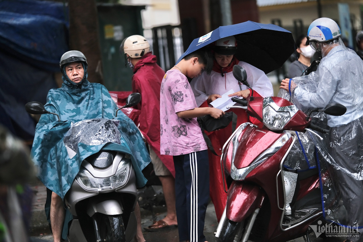 Sáng 9/6, các sĩ tử thi vào lớp 10 tại Hà Nội đến địa điểm thi trong điều kiện khó khăn về thời tiết khi trời có mưa.
