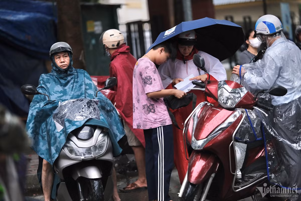 Sáng 9/6, các sĩ tử thi vào lớp 10 tại Hà Nội đến địa điểm thi trong điều kiện khó khăn về thời tiết khi trời có mưa.