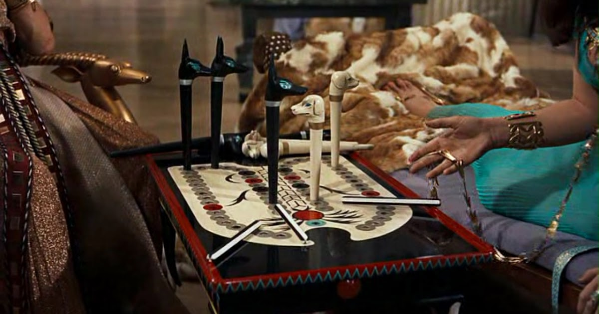 Trò chơi bao gồm một tấm bảng với 58 lỗ, sắp xếp thành hai hàng song song gồm 10 lỗ ở giữa và một vòng cung 38 lỗ bao quanh. Người chơi di chuyển năm quân dọc theo các lỗ từ điểm bắt đầu đến điểm cuối.