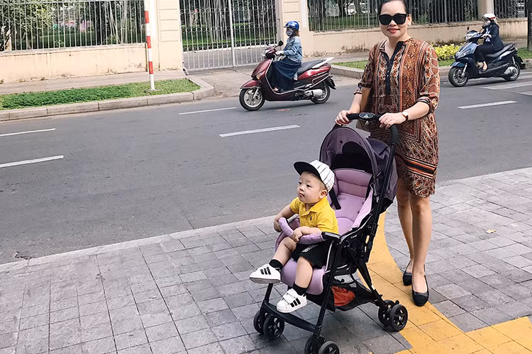 Từ nhỏ, bé Khoai Tây cũng được mẹ cho ăn diện sành điệu. Trong ảnh, cậu nhóc vui vẻ đi dạo phố cùng bà ngoại. (Ảnh: FBNV)