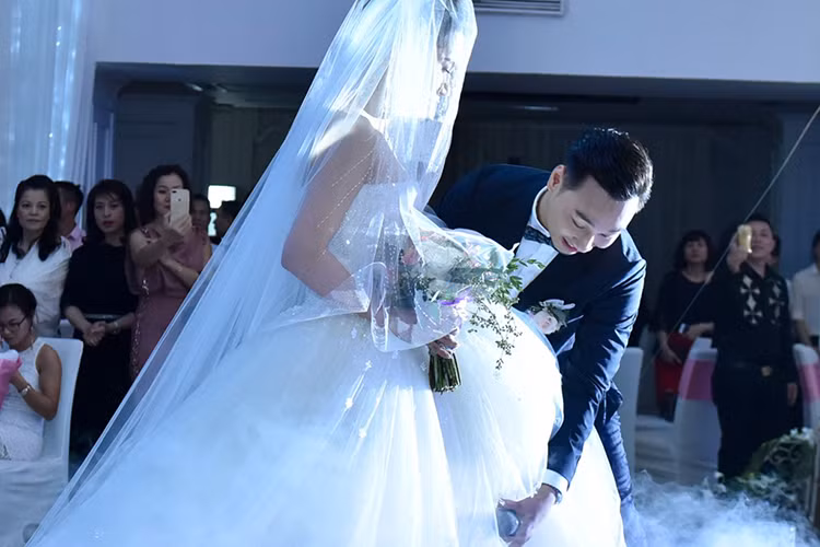 Tại tiệc cưới, chú rể Thành Trung cũng không ngần ngại nâng váy cho cô dâu Ngọc Hương. Ảnh: Zing