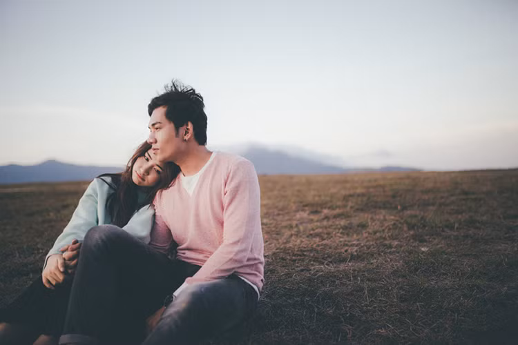 Hình ảnh Hòa Minzy ngồi trên đồi cao ngắm cảnh mặt trời lặn cùng con trai nuôi Hoài Linh trong sản phẩm âm nhạc mới.