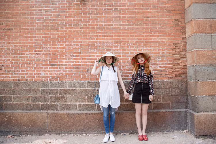 Chi Pu và Lee Sarah đội nón lá, thích thú chụp ảnh cùng nhau. Sau đó, cả hai ngồi xích lô dạo một vòng Sài Gòn.