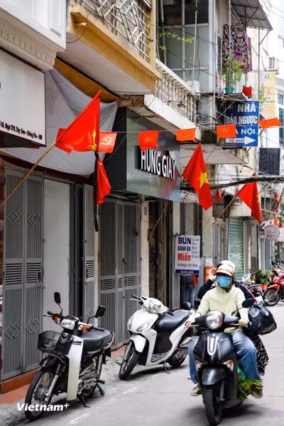 Không chỉ trên các con phố lớn mà những lá cờ rủ còn len lỏi vào nhưng ngõ ngách. Người dân đã treo cờ rủ tại một con ngõ trên phố Tây Sơn (quận Đống Đa). (Ảnh: Minh Hiếu/vietnam+)