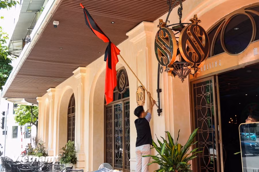 Một đơn vị kinh doanh trên phố Hai Bà Trưng đang treo cờ rủ để tưởng nhớ cố Tổng Bí thư Nguyễn Phú Trọng. (Ảnh: Minh Hiếu/vietnam+)