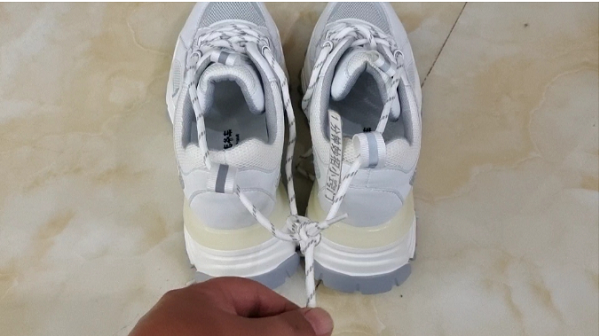 Tương tự, khi giày bị dính bẩn, nếu không muốn chạm tay vào giày thì bạn có thể dùng dây xỏ hai chiếc vào với nhau rồi nhấc lên.