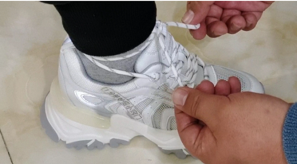 Lúc này, bạn nên lấy dây giày quấn quanh phần “đuôi nhỏ” phía sau rồi buộc chặt lại. Cách làm sẽ giúp bạn cố định chân và giày, vận động mạnh hay đi nhanh đều không lo bị tuột.