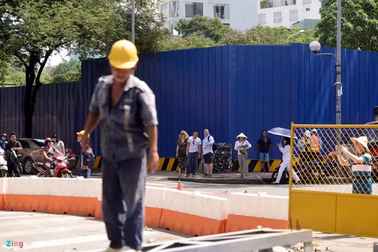 Việc đốn hạ cây dầu cổ thụ trên tuyến đường trung tâm quận 1 thu hút khiến nhiều người đi đường, khách du lịch quan tâm.