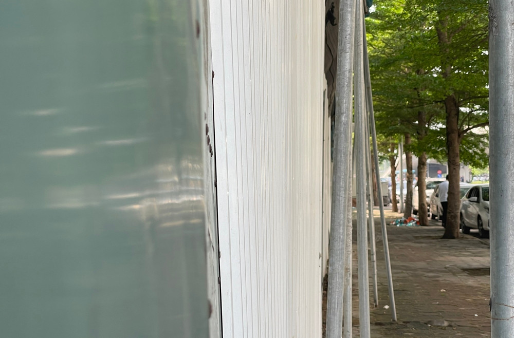 Hệ thống cột sắt dựng lên để che chắn lưới, bạt tại công trình này còn lấn ra vỉa hè đường Xuân Tảo.