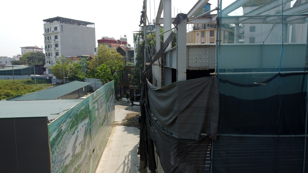 Hệ thống khung thép lớn, dầm chịu lực của công trình nằm chỏng chơ. Nằm kế công trình này là một Showroom ô tô.