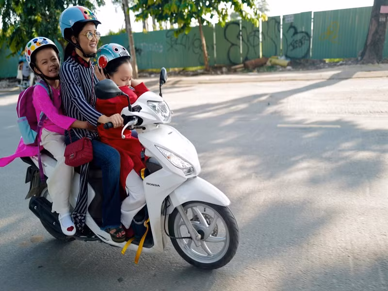"Cô Bống" thường lái xe máy chở các con đi học.